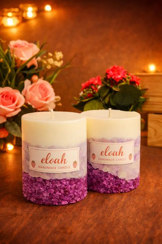 Velas de pilar con base morada junto a un ramo de rosas